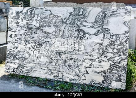 Grande lastra decorativa in marmo bianco con vene nere di Carrara, Toscana, Italia in piedi verticale all'aperto in mostra da vicino in una miniera a Foto Stock