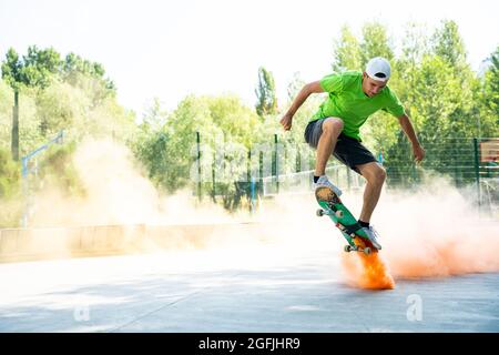 pattinatori con bombe fumanti colorate. Gli skateboarder professionisti si divertono allo skate Park Foto Stock