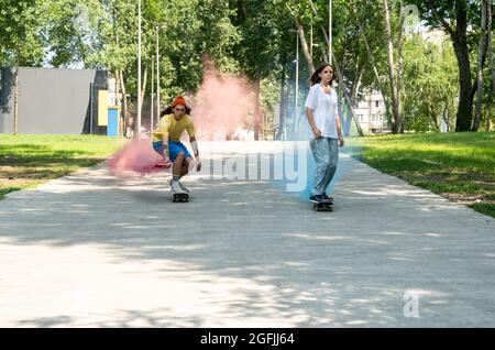 pattinatori con bombe fumanti colorate. Gli skateboarder professionisti si divertono allo skate Park Foto Stock