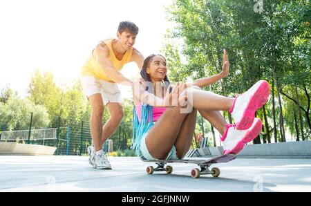 Gruppo di pattinatori adolescenti allo skatepark. Skateboarder professionisti che si divertono insieme Foto Stock