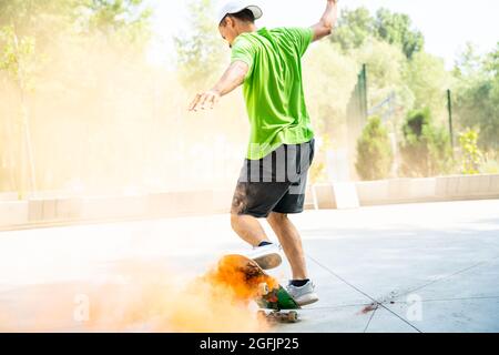 pattinatori con bombe fumanti colorate. Gli skateboarder professionisti si divertono allo skate Park Foto Stock