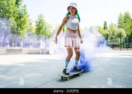 pattinatori con bombe fumanti colorate. Gli skateboarder professionisti si divertono allo skate Park Foto Stock