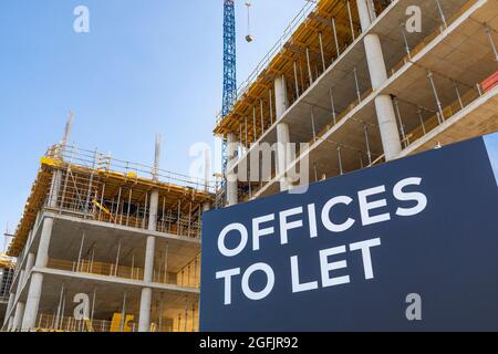 Cantiere, costruzione in costruzione con insegna e iscrizione: Uffici da lasciare Foto Stock