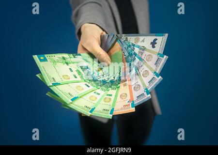 Primo piano della tenda in mano della donna su sfondo blu. Messa a fuoco selettiva. Foto Stock