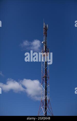 Antenna a relè a torre telefono cellulare alta su un bel cielo blu soleggiato a Crozon, Bretagna, Francia Foto Stock