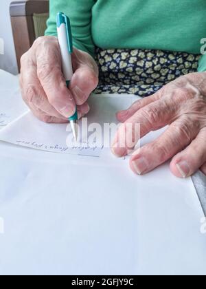 Donna anziana che fa la lista di shopping che dice un formaggio bianco in turco Foto Stock