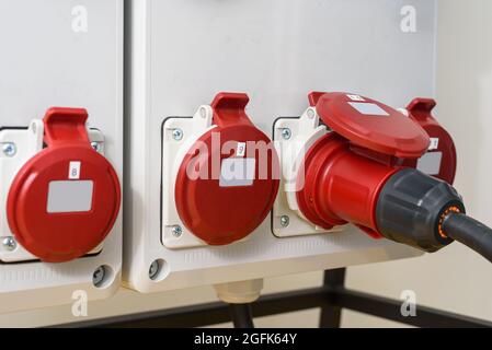 Prese industriali e spina sul quadro di distribuzione. Elettricità per cantiere, fornitura temporanea di energia Foto Stock