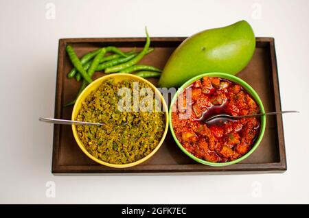 Raw Mango Pickle e Green Chilly Pickle achar posto su un vassoio di legno Studio Shot Foto Stock