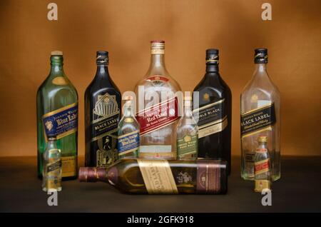 Set di bottiglie vuote di whisky premium Johnnie Walker su sfondo marrone Foto Stock