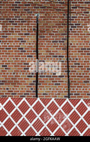 Una foto astratta di forme, colori, una recinzione, muro e fili in Queens, New York. Foto Stock