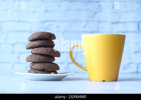 pila di biscotti al cioccolato e tazza di caffè sul tavolo Foto Stock