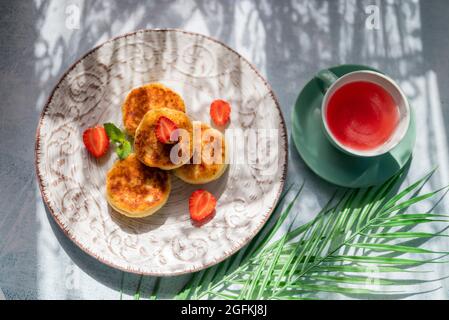 al mattino vi attende una prima colazione con pancake al formaggio e una tazza di tè alla luce del sole nel ristorante Foto Stock