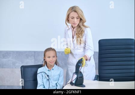 Paziente seduto nell'ufficio medico durante il test audiometrico Foto Stock