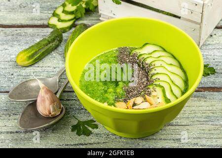 Gazpacho cetriolo. Zuppa estiva fresca verde. Verdure fresche, verdure verdi, spezie e posate. Vecchio legno assi sfondo, primo piano Foto Stock
