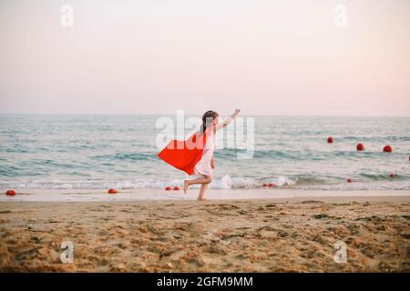 Ritratto di Superhero capretto su sfondo blu mare. Concetto di gioia e infanzia Foto Stock