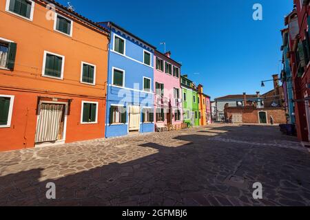 Vecchie piccole belle case multicolore (colori brillanti) nell'isola di Burano in una soleggiata giornata di primavera. Venezia, Veneto, Italia, Europa meridionale. Foto Stock