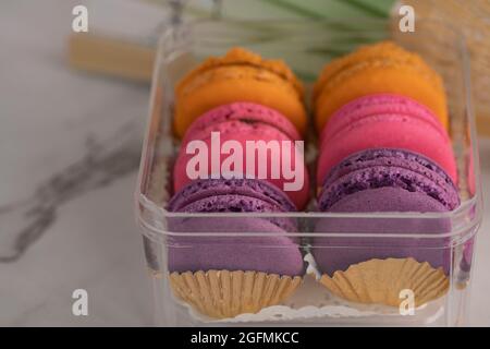 Primo piano di delizioso macaroon, un famoso dessert francese in un contenitore. Messa a fuoco selettiva. Sfondo sfocato Foto Stock