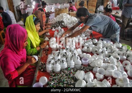 DHAKA CITY, BANGLADESH - AGOSTO 26: Un uomo sceglie le lampadine all'interno di una fabbrica di lampadine nella zona di Demra, durante il processo di produzione di lampadine a LED. I lavoratori della fabbrica sono donne a maggioranza su. Il 26 agosto 2021 a Dhaka, Bangladesh. (Foto di Maruf Rahman / Eyepix Group) (foto di Eyepix/Sipa USA) Foto Stock