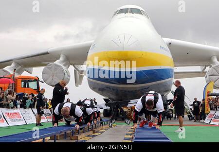 Hostomel, Ucraina. 26 agosto 2021. HOSTOMEL, UCRAINA - 26 AGOSTO 2021 - otto uomini forti tentano di tirare l'Antonov AN-225 Mriya che è l'aereo più pesante mai costruito nel tentativo di impostare il record per segnare 30 anni di indipendenza dell'Ucraina e il 75 ° anniversario della Società Antonov all'aerodromo Antonov, Hostomel, Regione di Kiev, Ucraina settentrionale. Gli atleti hanno tirato l'aereo 285t per quattro metri e 30 centimetri in un minuto e 13 secondi. Credit: Ukrinform/Alamy Live News Foto Stock