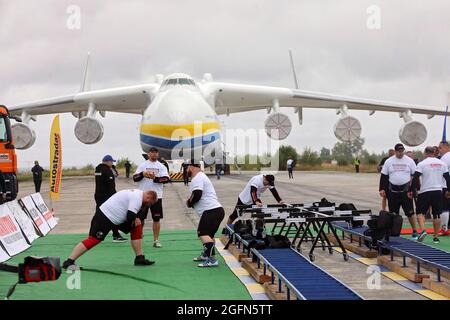 Hostomel, Ucraina. 26 agosto 2021. HOSTOMEL, UCRAINA - 26 AGOSTO 2021 - gli uomini forti ucraini si riscaldano prima di un tentativo di fissare il record per il tiro di Antonov AN-225 Mriya, l'aereo più pesante mai costruito, in occasione dei 30 anni di indipendenza dell'Ucraina e del 75° anniversario della Società Antonov presso l'aerodromo Antonov di Hostomel, Regione di Kiev, Ucraina settentrionale. Gli atleti hanno tirato l'aereo 285t per quattro metri e 30 centimetri in un minuto e 13 secondi. Credit: Ukrinform/Alamy Live News Foto Stock