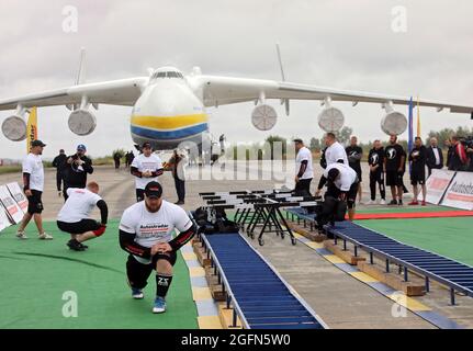 Hostomel, Ucraina. 26 agosto 2021. HOSTOMEL, UCRAINA - 26 AGOSTO 2021 - gli uomini forti ucraini si riscaldano prima di un tentativo di fissare il record per il tiro di Antonov AN-225 Mriya, l'aereo più pesante mai costruito, in occasione dei 30 anni di indipendenza dell'Ucraina e del 75° anniversario della Società Antonov presso l'aerodromo Antonov di Hostomel, Regione di Kiev, Ucraina settentrionale. Gli atleti hanno tirato l'aereo 285t per quattro metri e 30 centimetri in un minuto e 13 secondi. Credit: Ukrinform/Alamy Live News Foto Stock