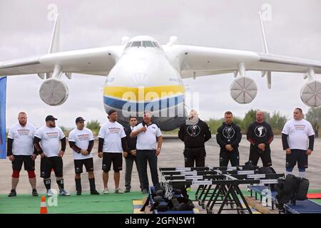 Hostomel, Ucraina. 26 agosto 2021. HOSTOMEL, UCRAINA - 26 AGOSTO 2021 - i giudici e gli uomini di forza ucraini sono raffigurati prima di un tentativo di fissare il record per il tiro di Antonov an-225 Mriya, l'aereo più pesante mai costruito, In occasione dei 30 anni di indipendenza dell'Ucraina e del 75° anniversario della Compagnia Antonov presso l'aerodromo Antonov, Hostomel, Regione di Kiev, Ucraina settentrionale. Gli atleti hanno tirato l'aereo 285t per quattro metri e 30 centimetri in un minuto e 13 secondi. Credit: Ukrinform/Alamy Live News Foto Stock