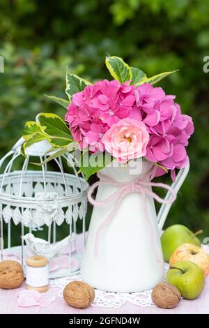 romantico bouquet di rosa rosa e fiori di ortangea in vaso d'epoca Foto Stock