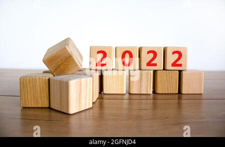 2022 felice anno nuovo simbolo. I cubi di legno simboleggiano il cambiamento dal 2021 al nuovo anno 2022. Bellissimo sfondo bianco. Spazio di copia. Business e 202 Foto Stock