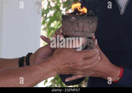 Non esclusiva: TEOTIHUACAN, MESSICO - AGOSTO 26: Un uomo esegue un rituale con (Copal) resine aromatiche vegetali prima vestito come guerriero azteco come parte Foto Stock