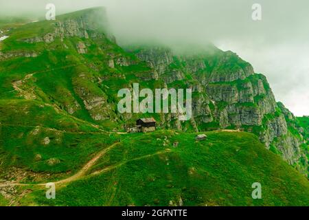 Fotografia paesaggistica della cabina di montagna Caraiman, situata nei Monti Bucegi, in Romania. La foto è stata scattata a distanza con la cresta nella parte posteriore. Foto Stock