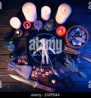 Voodoo su un tavolo magico con oggetti esoterici e candele brucianti per un  magico rituale di vendetta Foto stock - Alamy
