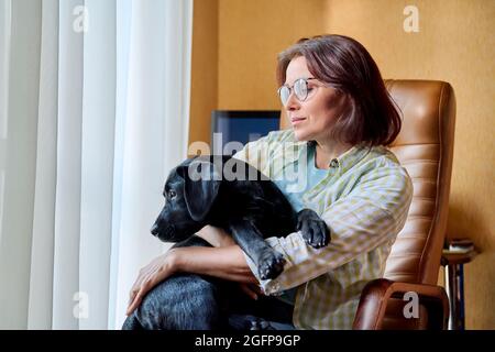 Ritratto di donna di mezza età e nero labrador cucciolo cane Foto Stock