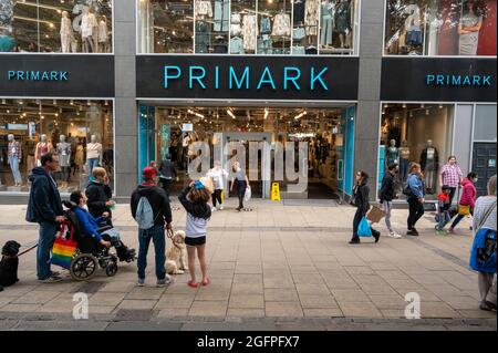 Negozio di moda Primark a Norwich con gli acquirenti che escono dal negozio che trasportano le borse Foto Stock