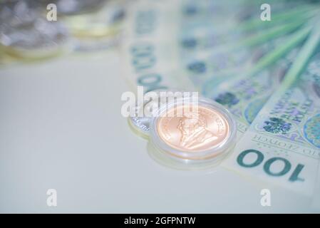 Varsavia, Polonia 03.05.2021 Ducat in un contenitore trasparente di plastica circolare chiuso su una moneta di carta spalmata in un ventilatore su una superficie bianca. Foto di alta qualità Foto Stock