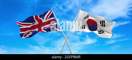 Bandiere della Gran Bretagna e della corea del Sud che ondeggiano nel vento su flagpoli contro il cielo con le nuvole in giorno di sole. Simbolizzazione del rapporto, dialogo tra Foto Stock