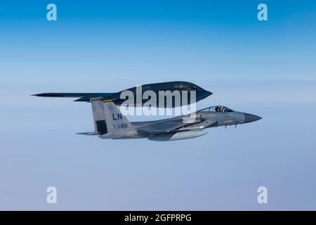 Mare del Nord, Regno Unito. 25 ago 2021. Un aereo da caccia F-15C Eagle dell'Aeronautica militare statunitense, assegnato al 493mo Squadrone Fighter, vola accanto a un bombardiere B-2 Spirit Stealth durante un sortie di addestramento sul Mare del Nord 25 agosto 2021 al largo della costa della Scozia. Credit: Planetpix/Alamy Live News Foto Stock