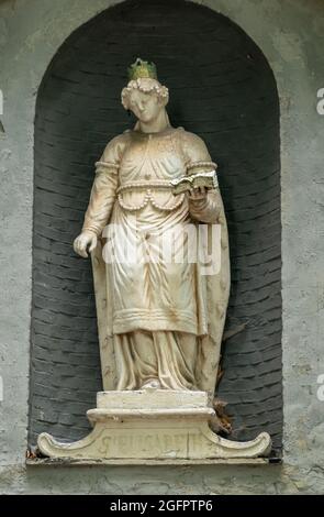 Brugge, Fiandre, Belgio - 4 agosto 2021: Beguinage chiesa, fuori sopra l'ingresso. Primo piano della statua bianca di Santa Elisabetta d'Ungheria. Foto Stock