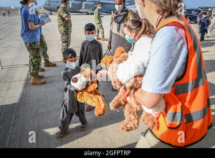 Sigonella, Italia. 26 agosto 2021. I membri del Dipartimento di Stato degli Stati Uniti distribuiscono giocattoli e forniture agli evacuati afghani dopo l'arrivo alla Stazione aeronavale di Sigonella il 26 agosto 2021 a Sigonella, Italia. NAS Sigonella fornisce alloggio temporaneo per gli evacuati dall'Afghanistan come parte dell'operazione Rifugi Alleati. Credit: Planetpix/Alamy Live News Foto Stock