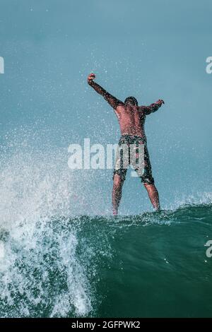 Un esperto surfer professionista sembra stare in piedi sull'acqua quando prendono una grande onda alla costa pacifica del Costa Rica Foto Stock