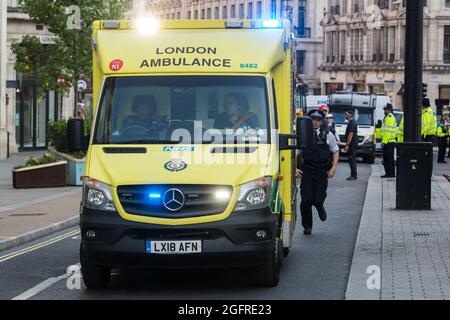 Londra, Regno Unito. 25 agosto 2021. Un'ambulanza londinese arriva durante un'operazione di polizia metropolitana per rimuovere attivisti ambientali femminili e di FINT-identificanti dalla ribellione di estinzione da un blocco stradale rosa a Oxford Circus durante il terzo giorno di impossibile protesta della ribellione. Estinzione la ribellione sta chiedendo al governo britannico di cessare tutti i nuovi investimenti di combustibili fossili con effetto immediato. Credit: Mark Kerrison/Alamy Live News Foto Stock