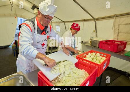 Grafschaft, Germania. 23 Agosto 2021. L'equipaggio della cucina del centro di ristorazione tedesco della Croce Rossa sta già cucinando il pranzo al mattino. Qui, più di 10000 pasti sono preparati tre volte al giorno per le vittime del disastro alluvionale dell'Ahr e per i numerosi aiutanti. Credit: Thomas Frey/dpa/Alamy Live News Foto Stock