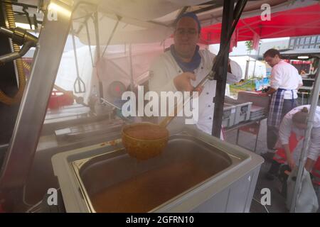 Grafschaft, Germania. 23 Agosto 2021. L'equipaggio della cucina del centro di ristorazione tedesco della Croce Rossa sta già cucinando il pranzo al mattino. Qui, più di 10000 pasti sono preparati tre volte al giorno per le vittime del disastro alluvionale dell'Ahr e per i numerosi aiutanti. Credit: Thomas Frey/dpa/Alamy Live News Foto Stock