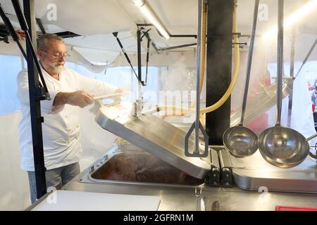 Grafschaft, Germania. 23 Agosto 2021. L'equipaggio della cucina del centro di ristorazione tedesco della Croce Rossa sta già cucinando il pranzo al mattino. Qui, più di 10000 pasti sono preparati tre volte al giorno per le vittime del disastro alluvionale dell'Ahr e per i numerosi aiutanti. Credit: Thomas Frey/dpa/Alamy Live News Foto Stock