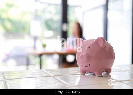 Primo piano, banca piggy sulla scrivania con sfondo sfocato, concetto di risparmio di denaro, Foto Stock