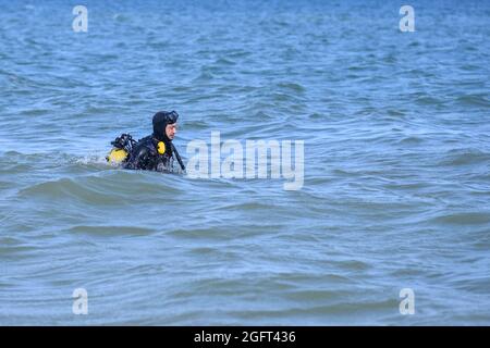 un uomo in una tuta subacquea entra in acqua. Editoriale Foto Stock