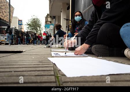 I manifestanti fanno segni e striscioni contro la brutalità della polizia durante un raduno organizzato dagli studenti dell'Universidad Distrital, dopo pochi giorni fa Esteban Mosquera, un leader sociale e membro della comunità è stato ucciso due anni dopo aver perso l'occhio su un caso di brutalità della polizia, a Bogotà, Colombia, il 26 agosto, 2021. Foto Stock