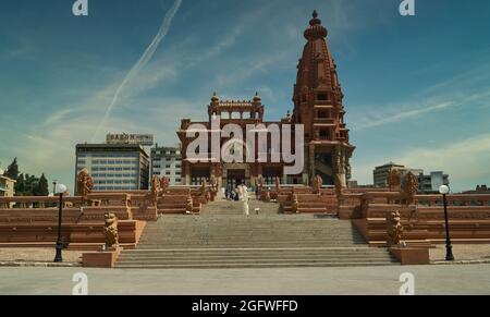 Baron Empain Palace (le Palais Hindou) al Cairo, Egitto esterno luce del giorno girato mostrando l'architettura unica del palazzo con i visitatori a piedi Foto Stock