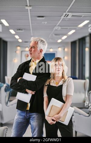 Colleghi che si levano in piedi insieme e guardano via Foto Stock