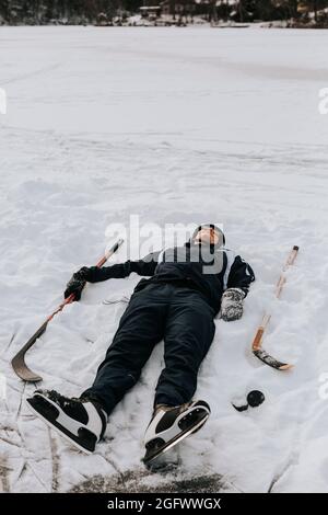 Uomo sorridente sdraiato sulla neve Foto Stock