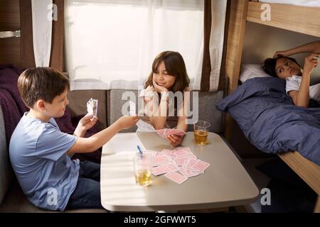 Bambini che giocano a carte in camper Foto Stock